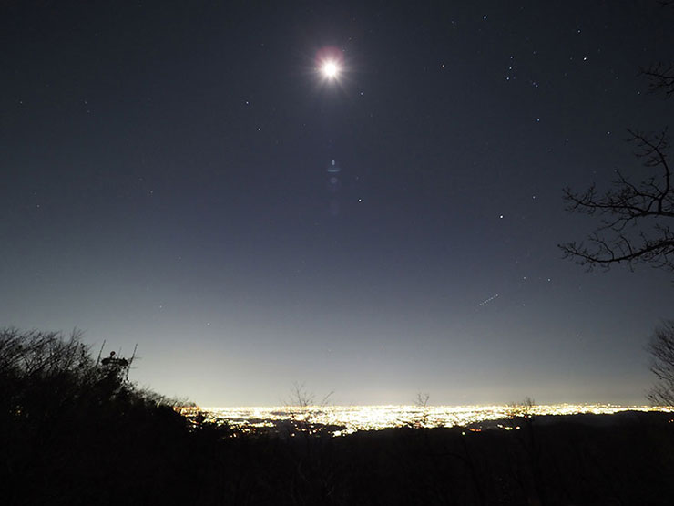 街の夜景と月の画像