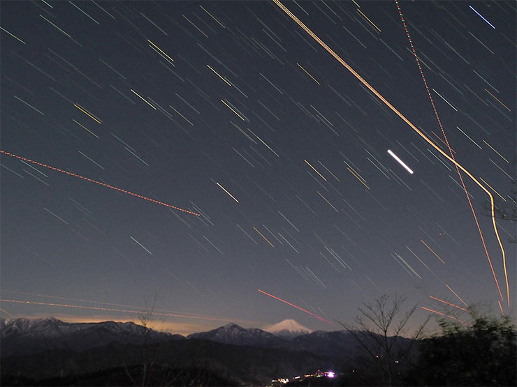 星と飛行機の光跡の画像