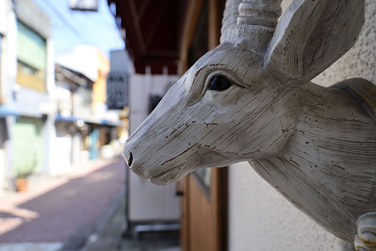 店頭に飾られた木製の鹿のオブジェの画像