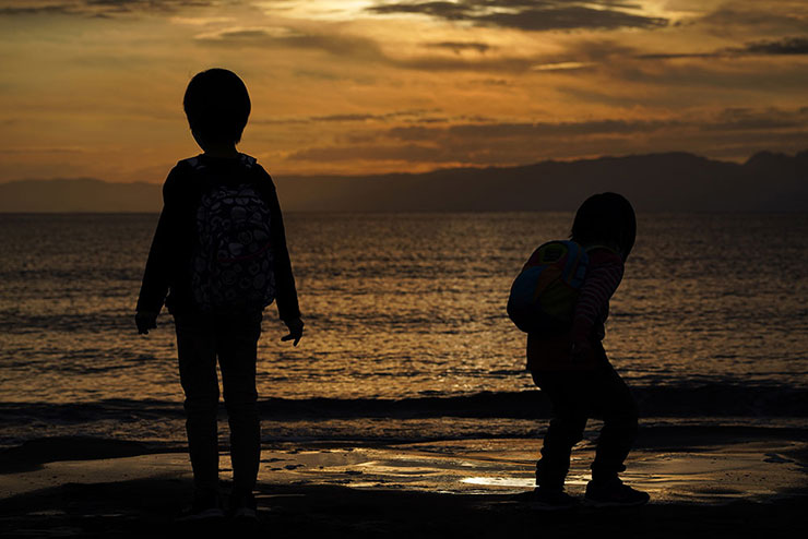 TAMRON 70-300mm F/4.5-6.3 Di III RXD (Model A047)で撮影した夕暮れ時に波と戯れる子供たちの画像