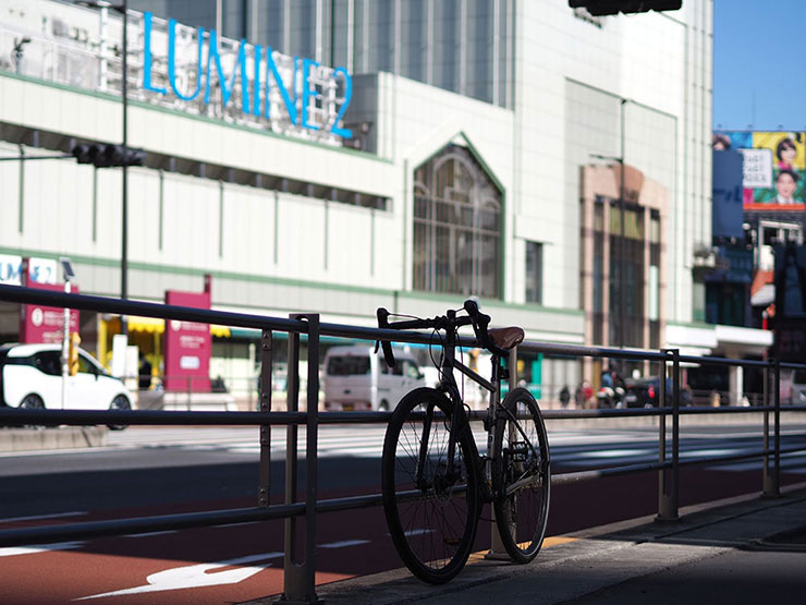 OLYMPUS M.ZUIKO DIGITAL 45mm F1.8で撮影した歩道に停めてある自転車の画像