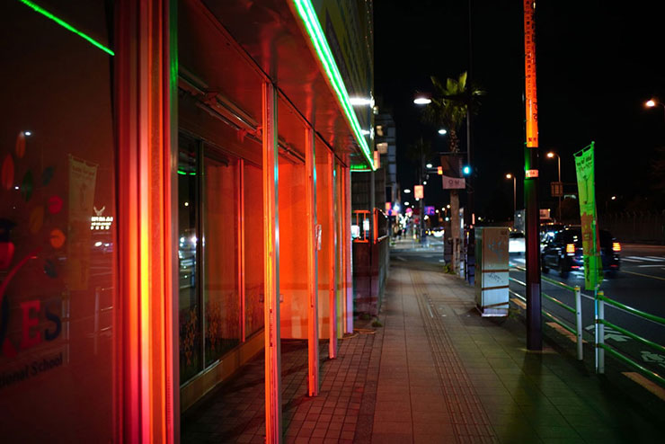 Voigtlander ULTRON Vintage Line 35mm F2 Aspherical TypeII VMで撮影した赤く照らされたお店と歩道の画像