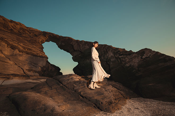 SONY α1・20mmで撮影した海岸の岩の上に立つ女性