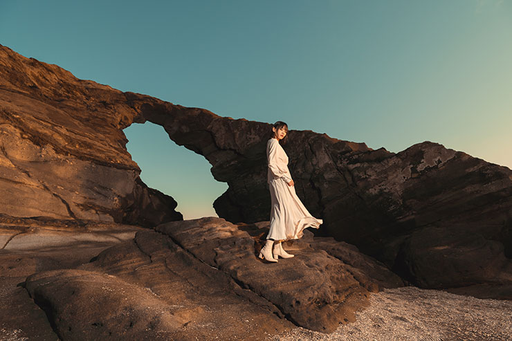 SONY α1・20mmで撮影した海沿いの岩の上に立つ女性