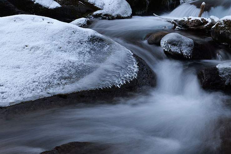 LUMIX S 20-60mm F3.5-5.6・43mmで撮影した雪が積もった岩の間を流れる川の画像
