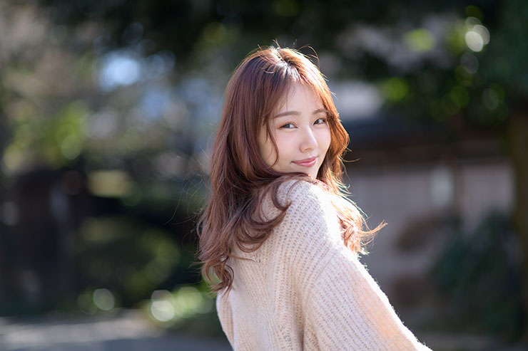 ニコン D850・AF-S NIKKOR 85mm f/1.4Gで撮影した微笑みながら振り返る女性の画像