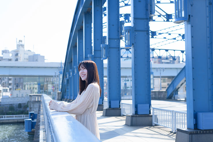 ニコン D850・AF-S NIKKOR 50mm f/1.4Gで撮影した橋に立っている笑顔の女性の画像