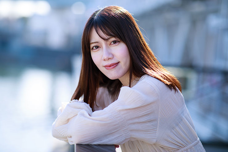 キヤノン EOS 5D MarkⅣ・EF85mm F1.4L IS USMで撮影した橋の欄干にもたれる女性の画像