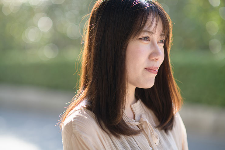 ニコン D850・AF-S NIKKOR 85mm f/1.4Gで撮影した微笑みながら遠くを見る女性の画像