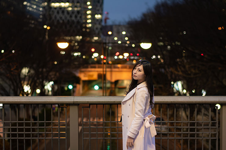 ニコン D850・AF-S NIKKOR 58mm f/1.4Gで撮影した夜の街の橋に立つ女性の画像