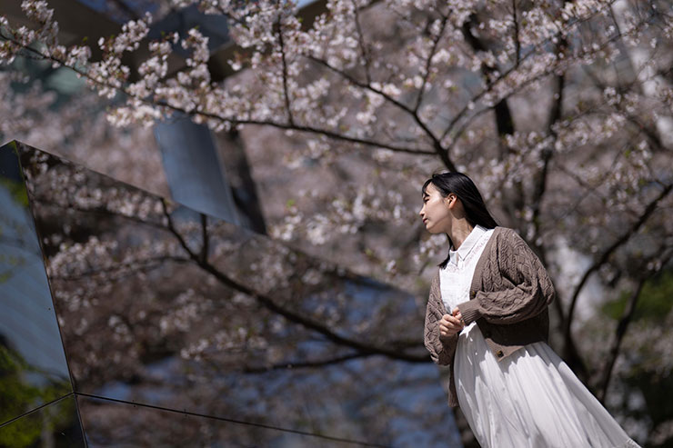ニコンZ 9・NIKKOR Z 85mm f/1.2 Sで撮影した桜の木の下に立つ女性の画像