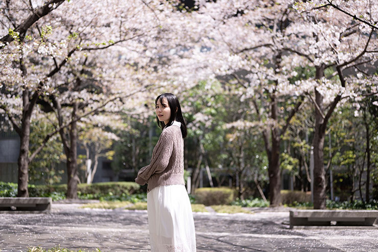 ニコンZ 9・NIKKOR Z 50mm f/1.8 Sで撮影した桜の木々を背景に振り返る女性の画像