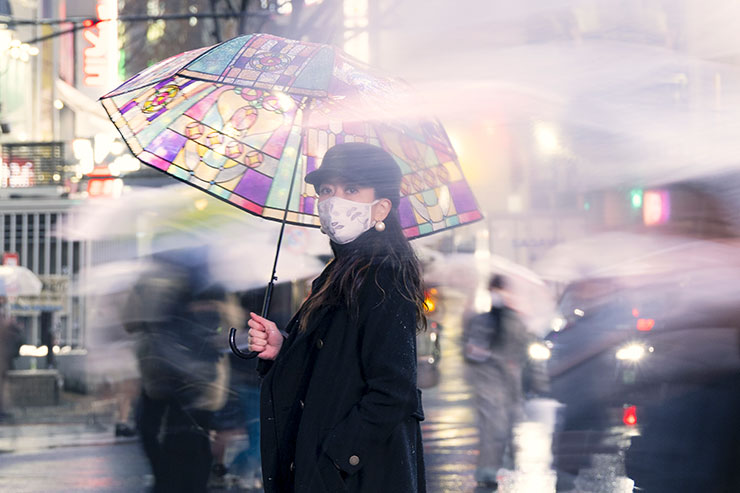 日の丸構図で撮影した雨傘をさしてスクランブル交差点で振り向く筆者の画像