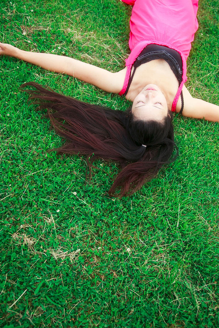 黄金比で撮影した芝生の上に仰向けに寝転がる女性の画像