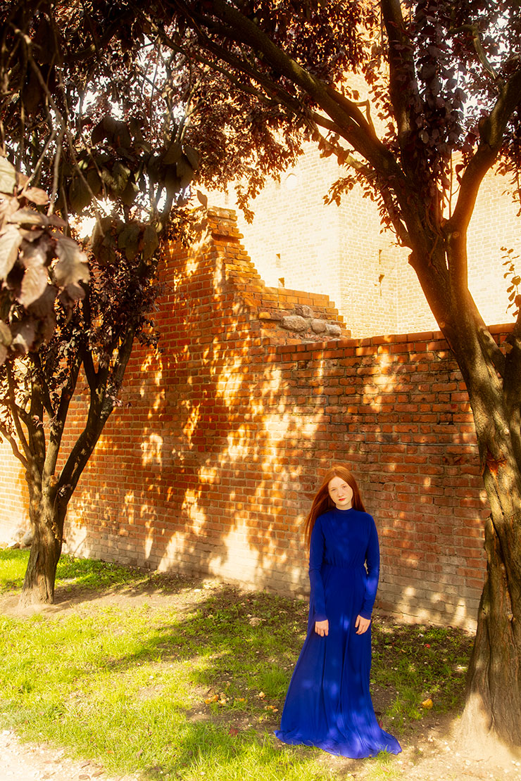 キヤノンEOS 5Ds R・EF24-105mm F4L IS USM（85mm）で撮影したレンガの壁と木の前に立っている女性の画像