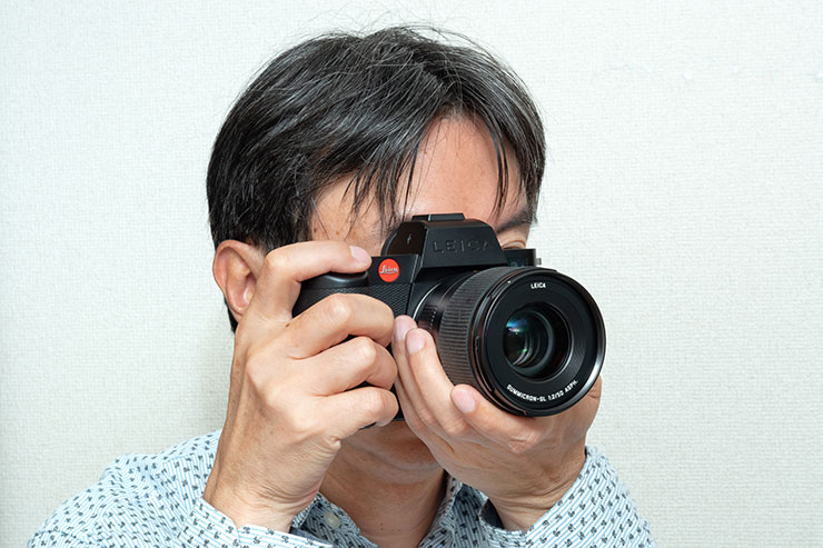 Leica ズミクロンSL f2/50mm ASPH.を装着したSL2-Sのファインダーを覗く筆者の画像