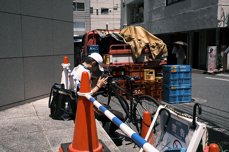 FUJIFILM  X-E4・Voigtlander ULTRON27mm F2 X-mountで撮影した駐車中のトラックや自転車、人の画像