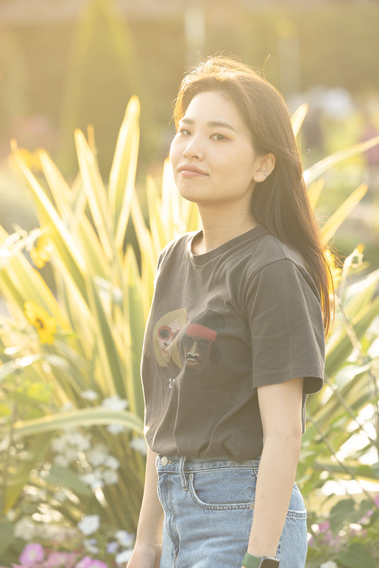 植物の前に立っている女性の画像