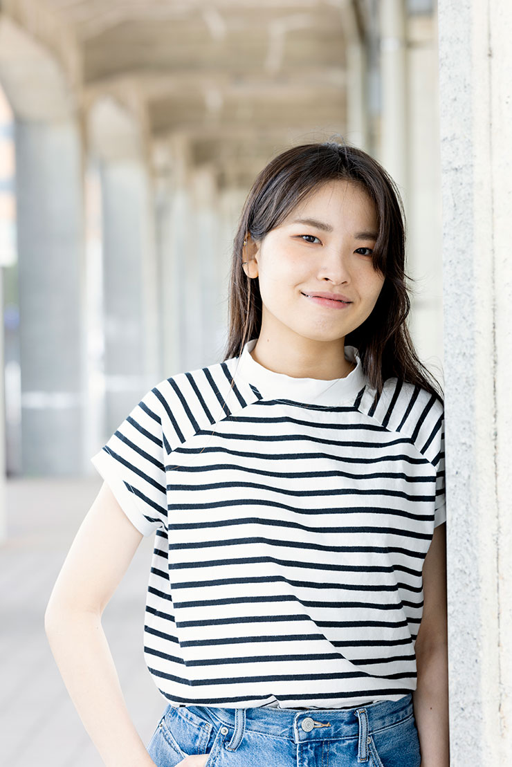 壁の横に立っている女性の画像