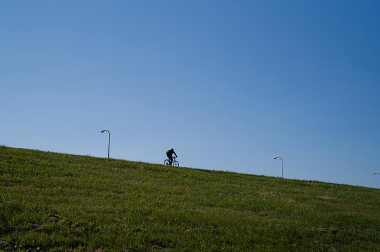 Leica M11-D 作例：土手を走る1台の自転車