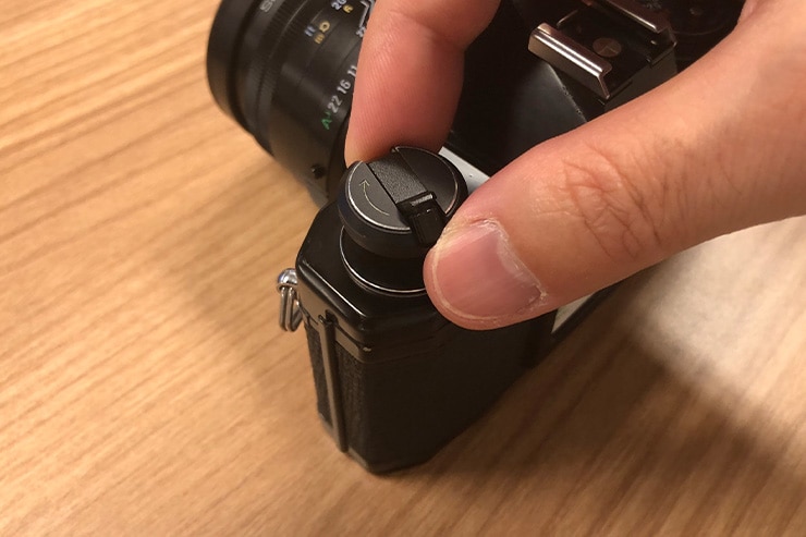 フィルムカメラの巻き戻しクランクを引き上げている画像