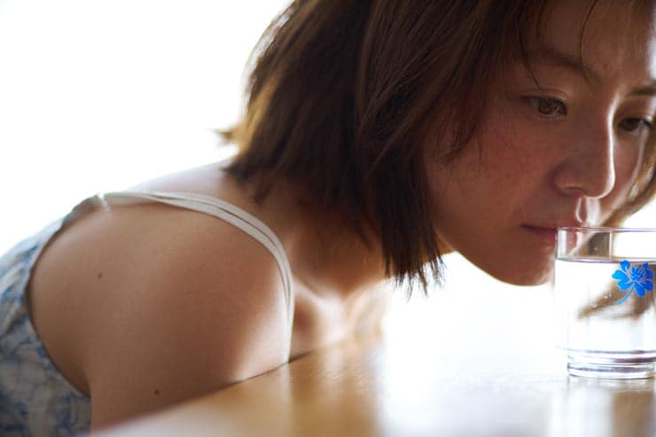 Voigtländer PORTRAIT HELIAR 75mm F1.8作例：机の上のコップの水を見つめる女性