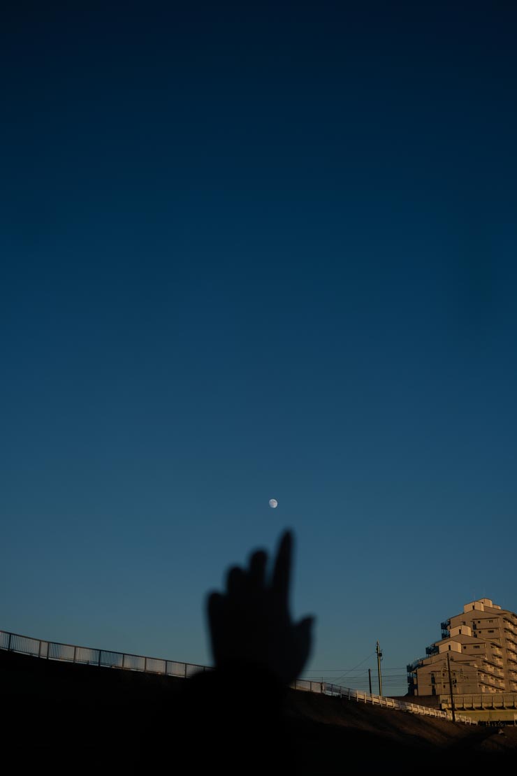 富士フイルム フジノンレンズ XF27mmF2.8 R WR作例：夕方の空、手のシルエット越しに月