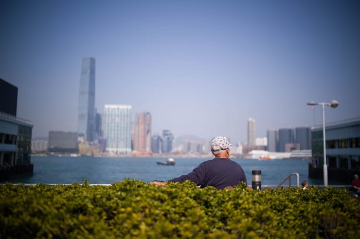 Leica ノクティルックスM F1.2/35mm ASPH.作例：対岸にビル群が見える海辺に座る男性