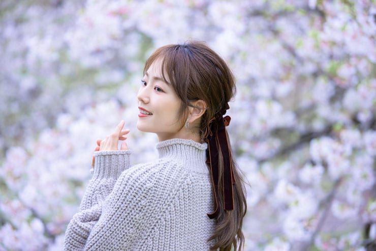 Nikon NIKKOR Z 70-200mm f/2.8 VR S II作例：満開の桜の前に立って振り返る女性